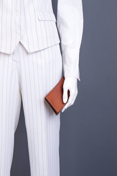 Vrouwelijke wit formele pak en bruine portemonnee. - Foto, afbeelding