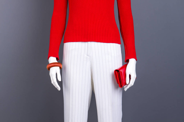 Schaufensterpuppe mit rotem Pullover, Armband und Brieftasche. - Foto, Bild