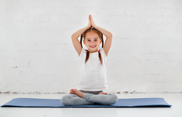 kind meisje doen yoga en turnen in sportschool - Foto, afbeelding