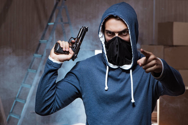 Aggressiver Mann mit Waffe trägt Gesichtsmaske - Foto, Bild