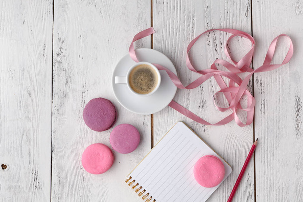 Pink macaroons with coffee cup on wooden table. Flat lay - Foto, immagini