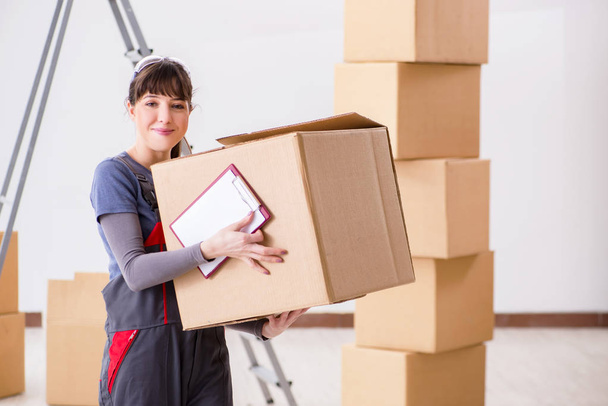Mujer contratista moviendo cajas en concepto de reubicación - Foto, imagen
