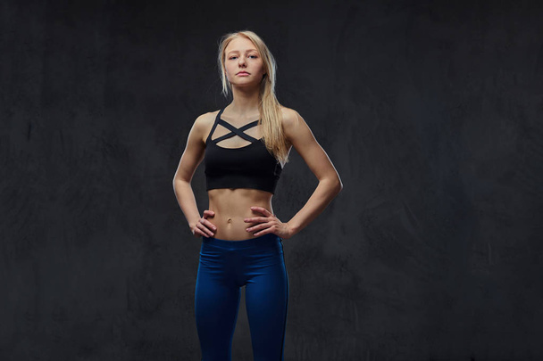 Sexy slim blonde girl in a sportswear posing in a studio. - Foto, immagini