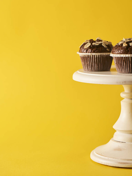 Two delicious chocolate muffins on yellow background. Minimal concept - Photo, Image