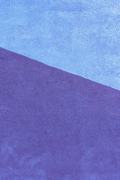 Parede com textura de gesso, pintada em duas cores. Azul e violeta em um dioganal. Belo fundo incomum
. - Foto, Imagem