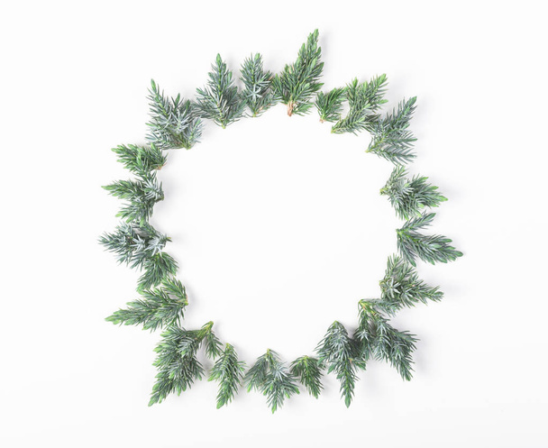 Round frame made of juniper branches isolated on white background. Top view with copy space. Flat lay. Christmas or New year composition. - Photo, Image