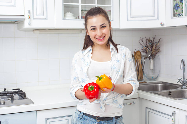 Young attractive woman cooking salad indoors at the kitchen - Foto, afbeelding