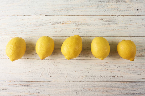 Fresh yellow lemons on white wooden background with space for text - Fotografie, Obrázek