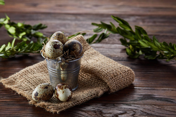 Spring composition of quail eggs in bucket on a linen napkin and boxwood branch, selective focus - Foto, immagini