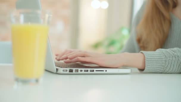 junge blonde Frau mit Laptop-Computer, während sie am Tisch sitzt. junge blonde Frau benutzt Laptop-Computer, während sie am Tisch sitzt. - Filmmaterial, Video