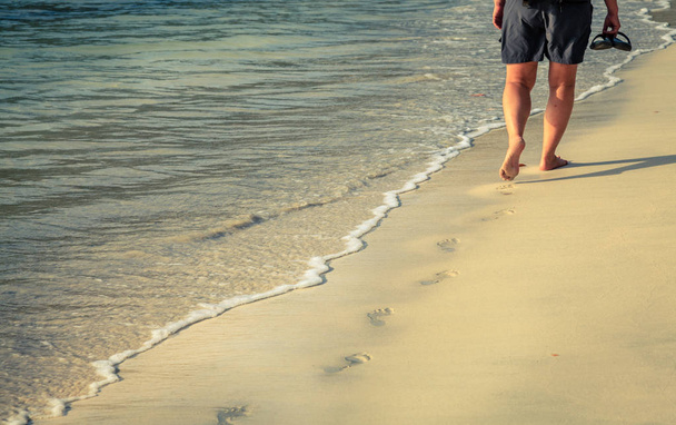 людина ходить уздовж берегової лінії острова
  - Фото, зображення