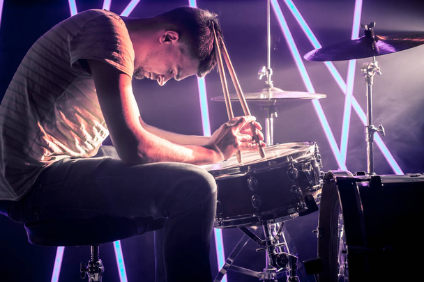 zamyšlený člověk hraje na bicí. Na pozadí barvy - Fotografie, Obrázek