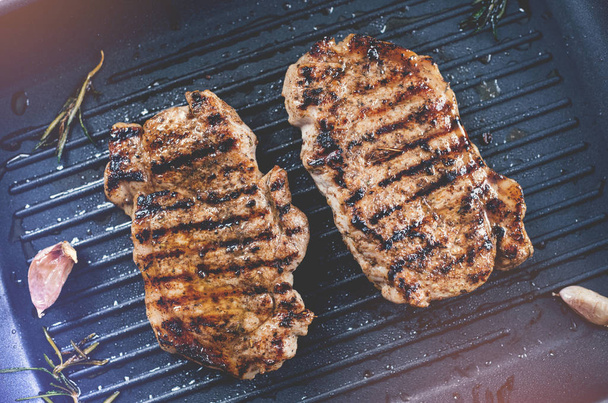 zwei gegrillte Steaks auf einer Grillpfanne. Ansicht von oben. - Foto, Bild