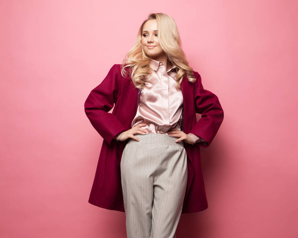 Beautiful model pose for a photo in trendy clothes over pink background - Valokuva, kuva
