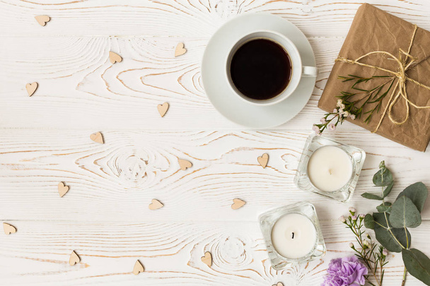 Top view of coffee, gifts, hearts, candles, flowers on white wooden table. Background with free space for text. Flat lay - Fotó, kép
