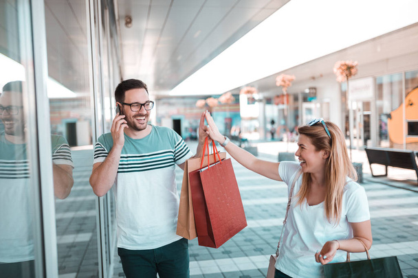 Beautiful couple enjoy shopping together in shopping mall - Foto, imagen