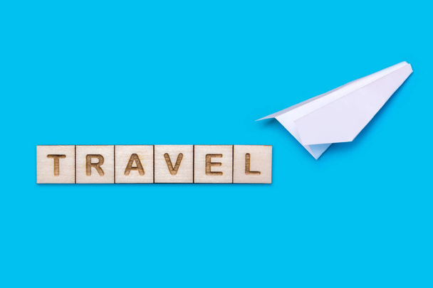 Αντίληψη για το θέμα του ταξιδιού. Λευκό origami αεροπλάνο σε μπλε φόντο - Φωτογραφία, εικόνα