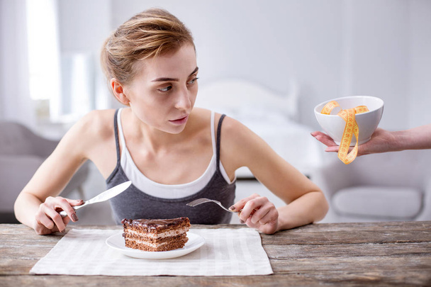 Nice young woman eating a cake - Fotoğraf, Görsel
