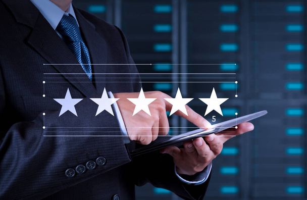 Pět hvězdiček (5) hodnocení se podnikatel se dotýká obrazovky virtuálního počítače. Pozitivní zpětná vazba zákazníků a s vynikajícím výkonem. - Fotografie, Obrázek