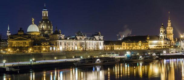 Vue panoramique nocturne de bâtiments historiques avec des reflets dans la rivière Elbe dans le centre de Dresde (Allemagne
). - Photo, image