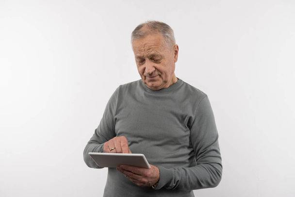 Pleasant aged man using a tablet - Fotoğraf, Görsel