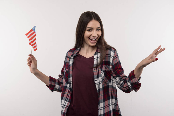 Joyful young woman holding the US symbol - 写真・画像