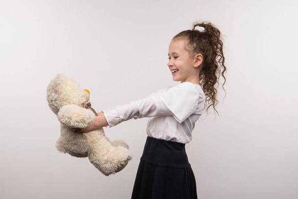 Delighted happy girl holding her bear - Photo, image