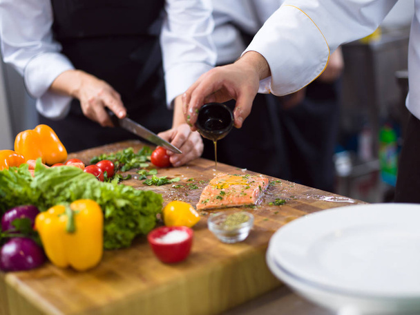 Chef hands preparing marinated Salmon fish - Photo, Image