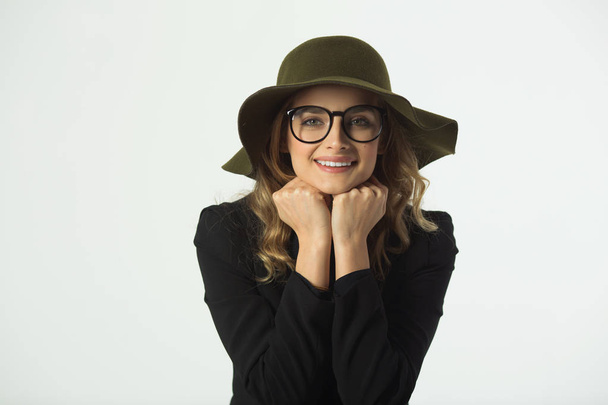 beautiful young girl with glasses and hat, wearing a black jacket on a white background - Photo, image