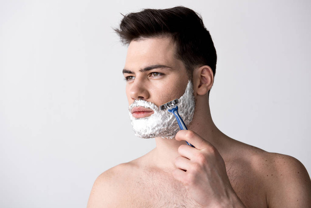 Gorgeous guy is using razor - Foto, imagen