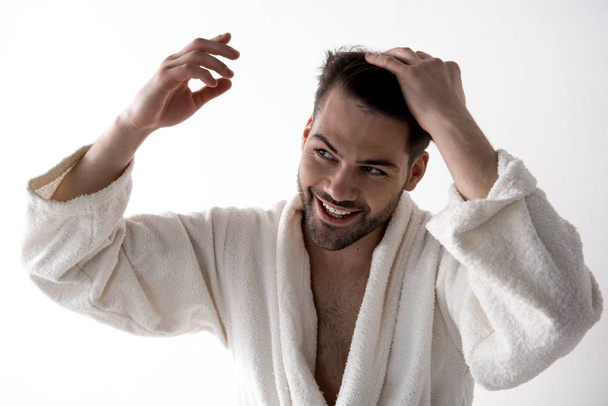 Positive cute bearded guy is making hairstyle - 写真・画像