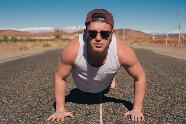 Αθλητικός τύπος στο δρόμο στην έρημο - Φωτογραφία, εικόνα