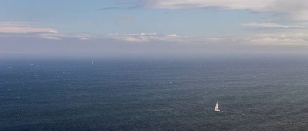 Velero en solitario en el mar
 - Foto, Imagen