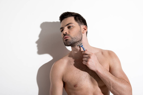 Young man is removing unwanted hair from his neckline - Foto, immagini