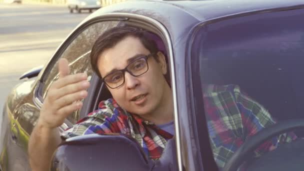 Сердитий людина водіння автомобіля агресивну поведінку на дорозі, водій в окулярах - Кадри, відео
