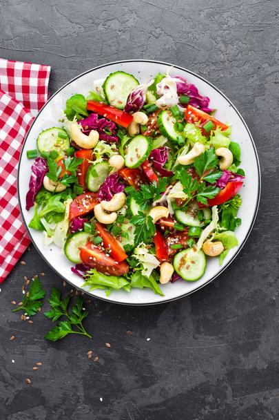 Vegetable salad. Fresh salad with vegetables and nuts. Vegetable salad on plate. Healthy vegetarian food - Foto, immagini