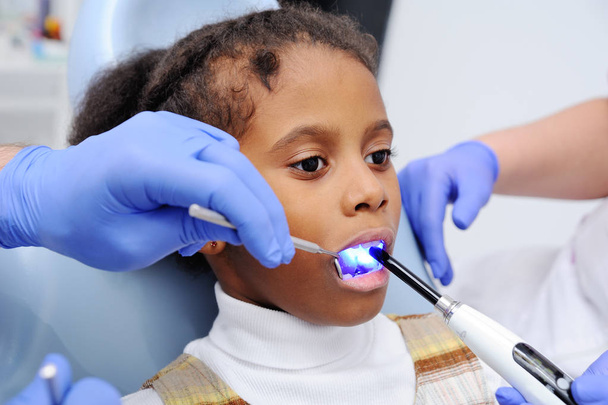 a dark-skinned baby girl in the dentists chair - Photo, image