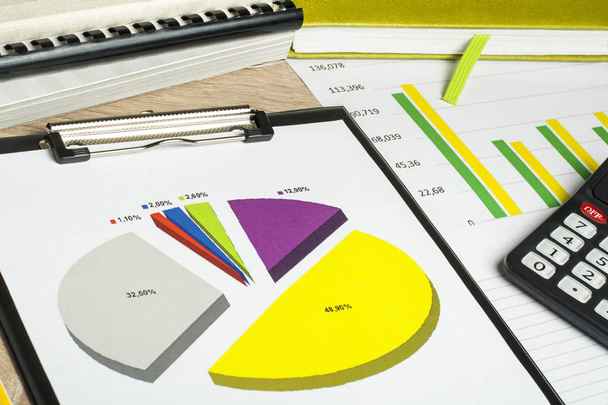 Wykresy, ksiąg rachunkowych i Kalkulator na stół drewniany office. Koncepcja finansowych i budżetowych. - Zdjęcie, obraz