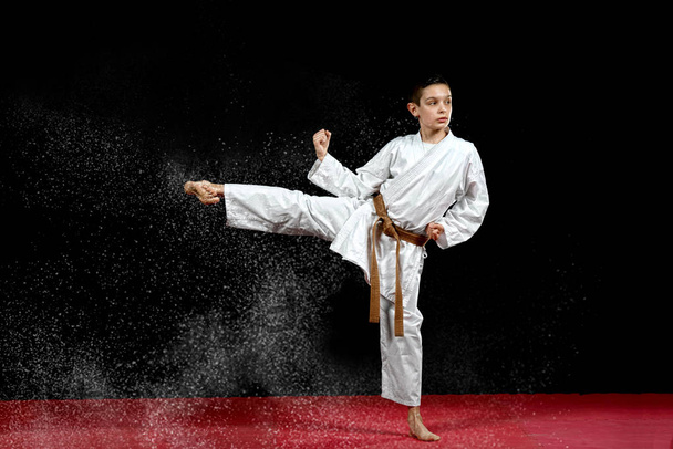 One little boy in white kimono during training karate kata exercises - Photo, Image
