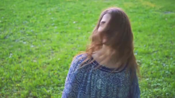 Young attractive girl twirls hair in the park closeup. slow motion - Πλάνα, βίντεο