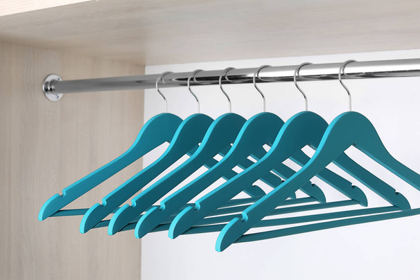 Clothes hangers on metal rail in wardrobe - Фото, зображення