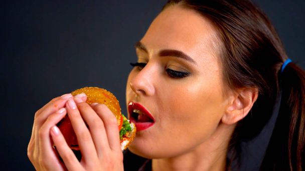 Nő eszik hamburgert. Lány azt akarja, hogy enni gyorsétterem. - Fotó, kép