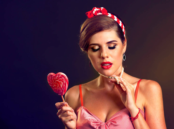 Woman eating lollipops. Girl in pin-up style hold striped candy. - Foto, Imagem