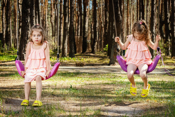 little girls are swinging on swings - Foto, Imagen