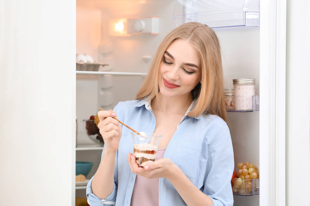 Nuori nainen jogurtti keittiössä
 - Valokuva, kuva