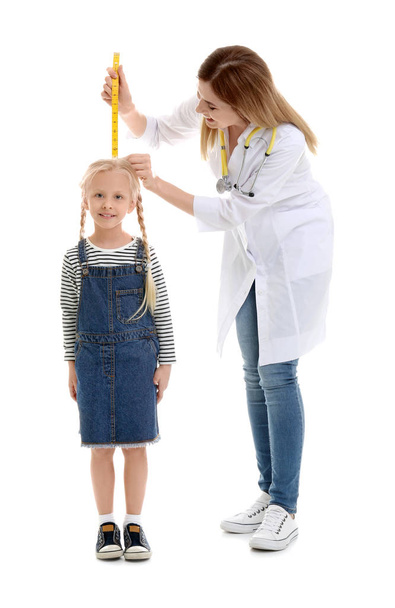 Doctor measuring little girl's height on white background - 写真・画像