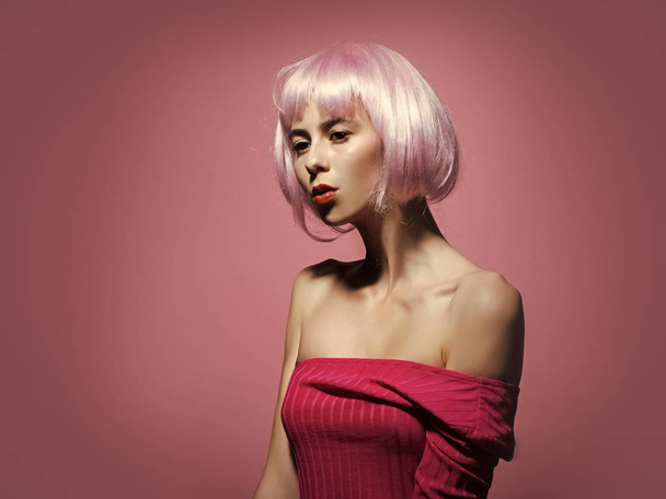 Mulher em peruca no fundo rosa com maquiagem elegante
 - Foto, Imagem