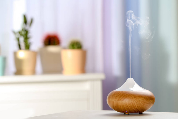 Aroma oil diffuser on table in room. Air freshener - Fotoğraf, Görsel