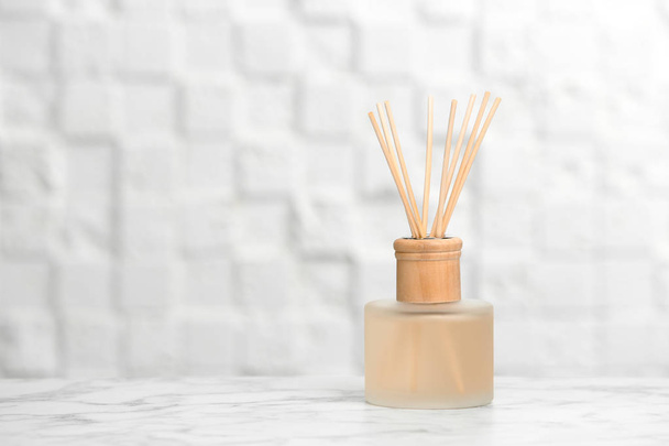 Aromatic reed freshener on table against light background - Fotoğraf, Görsel