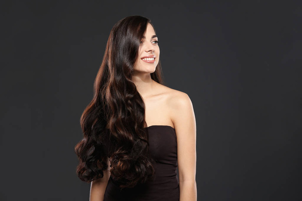 Portrait of beautiful model with gorgeous curly hair on black background - Zdjęcie, obraz